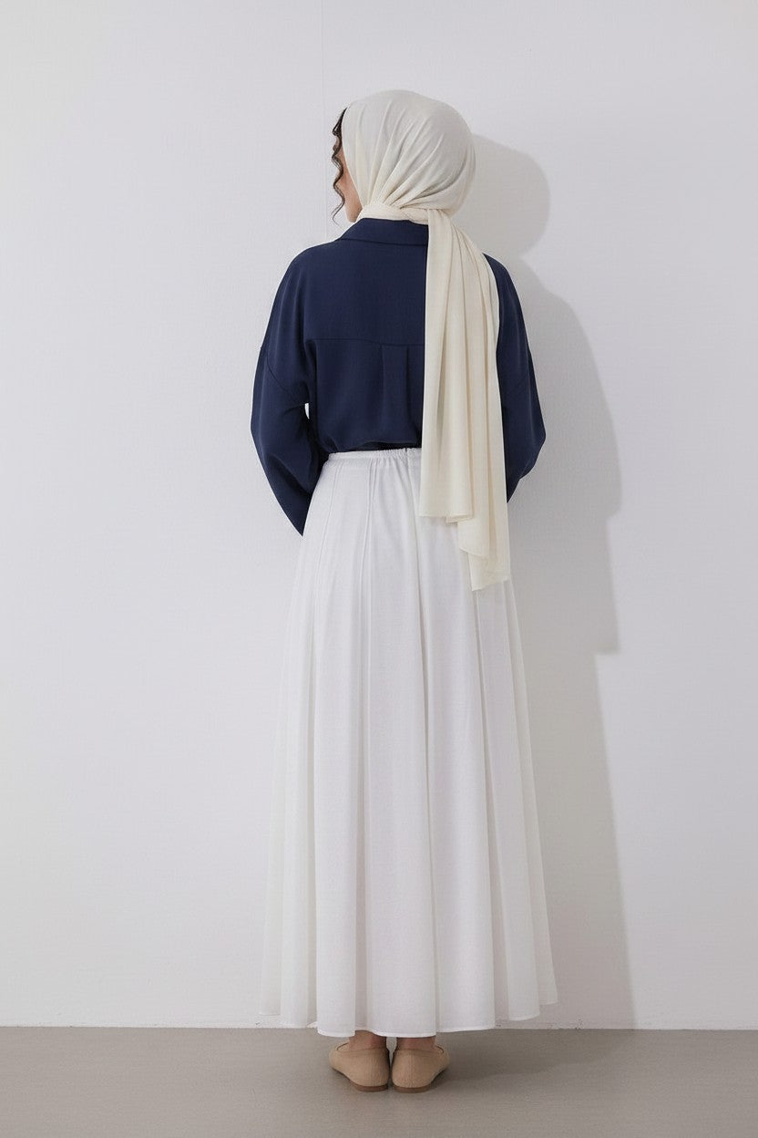 Cherianne.com navy blue linen-blend blouse with drop sleeves and mother-of-pearl buttons, worn with a white skirt.