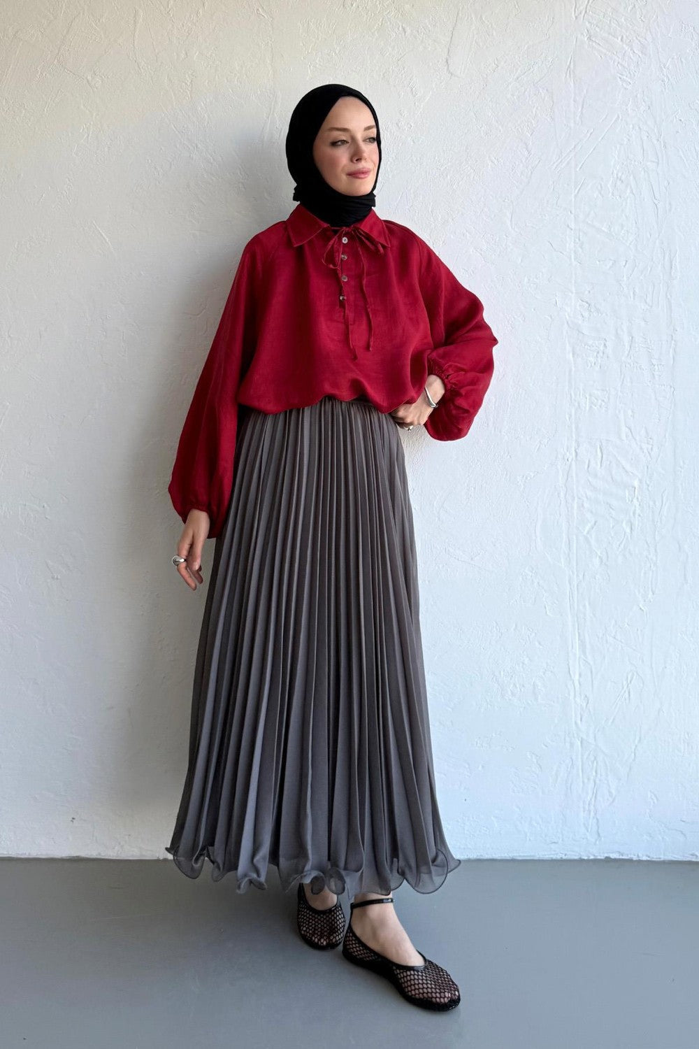 Cherianne.com gray pleated chiffon maxi skirt worn by a model with a red blouse and black hijab