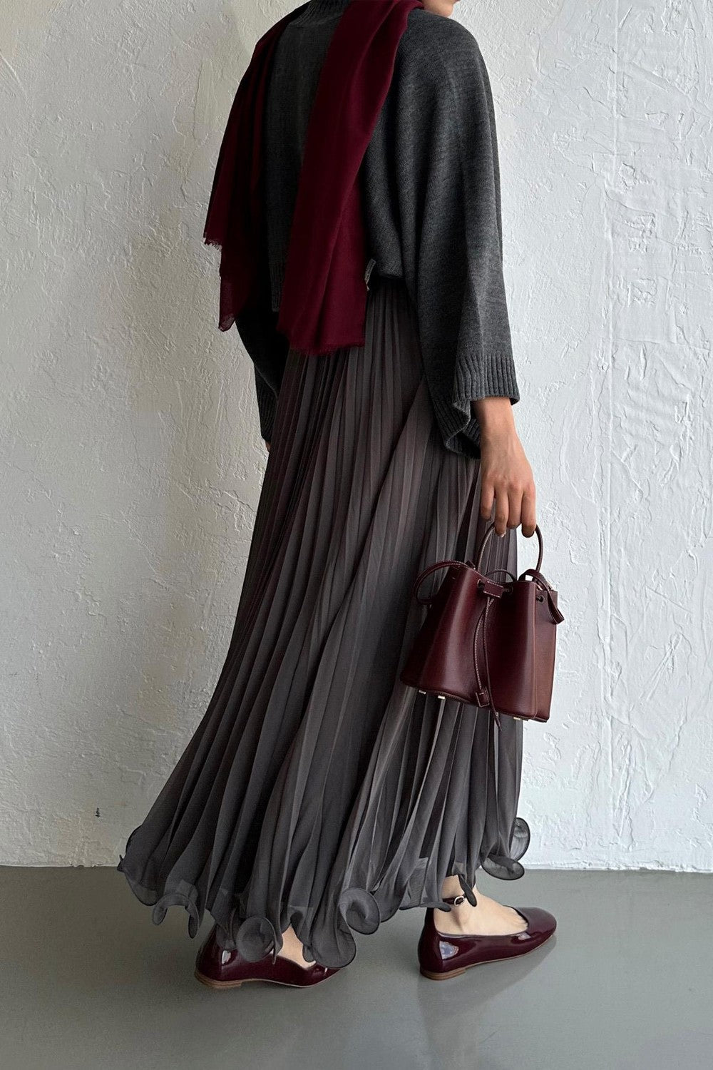 Cherianne.com gray pleated chiffon maxi skirt paired with a dark sweater, burgundy scarf, and matching handbag.