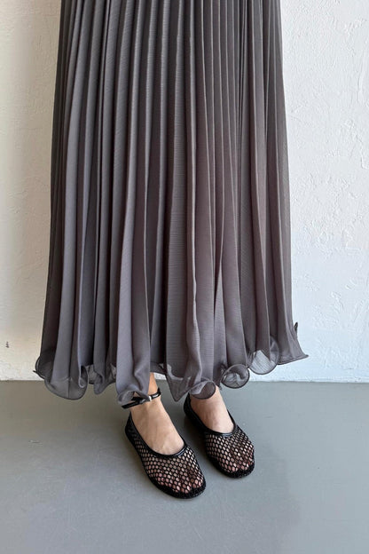 Cherianne.com gray pleated chiffon maxi skirt with a flowy hemline worn with black mesh flats