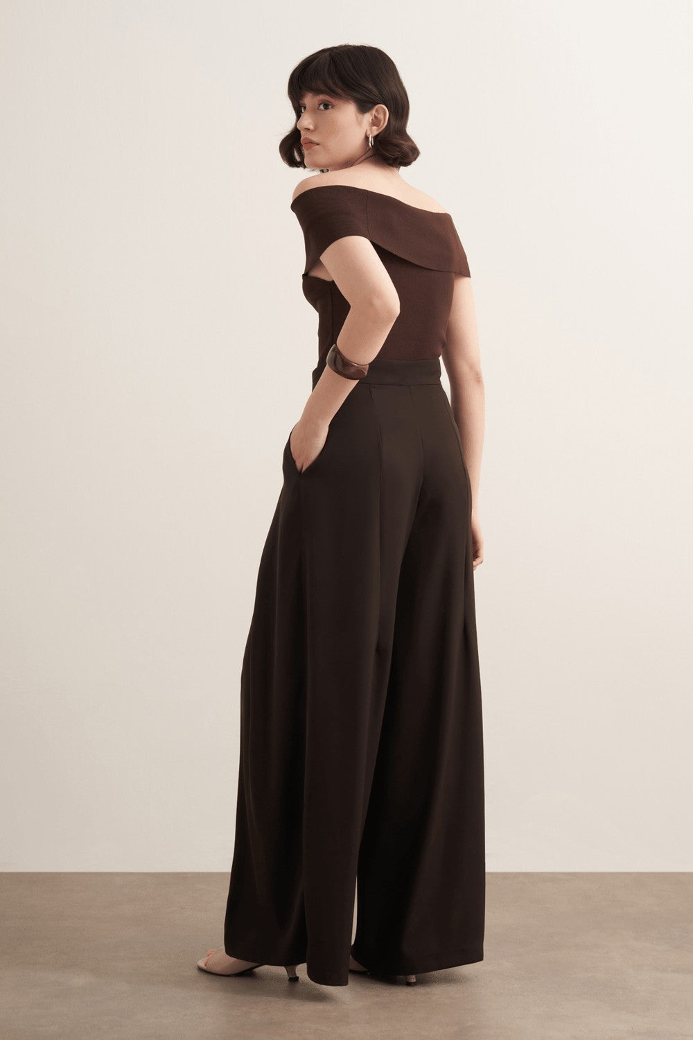 Cherianne.com Leona high-waisted wide-leg trousers in dark brown polyester with a ruffled design and side pockets.