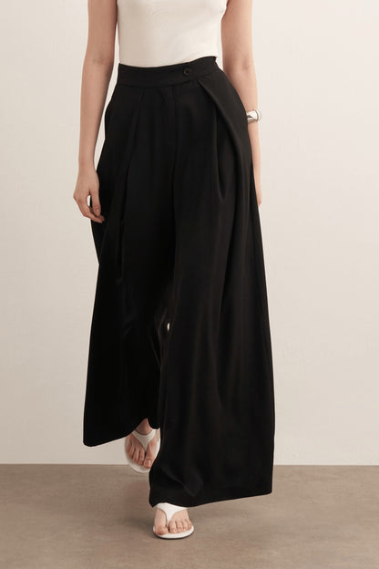 Cherianne.com model wearing black high-waisted wide-leg trousers with a ruffled design and side pockets