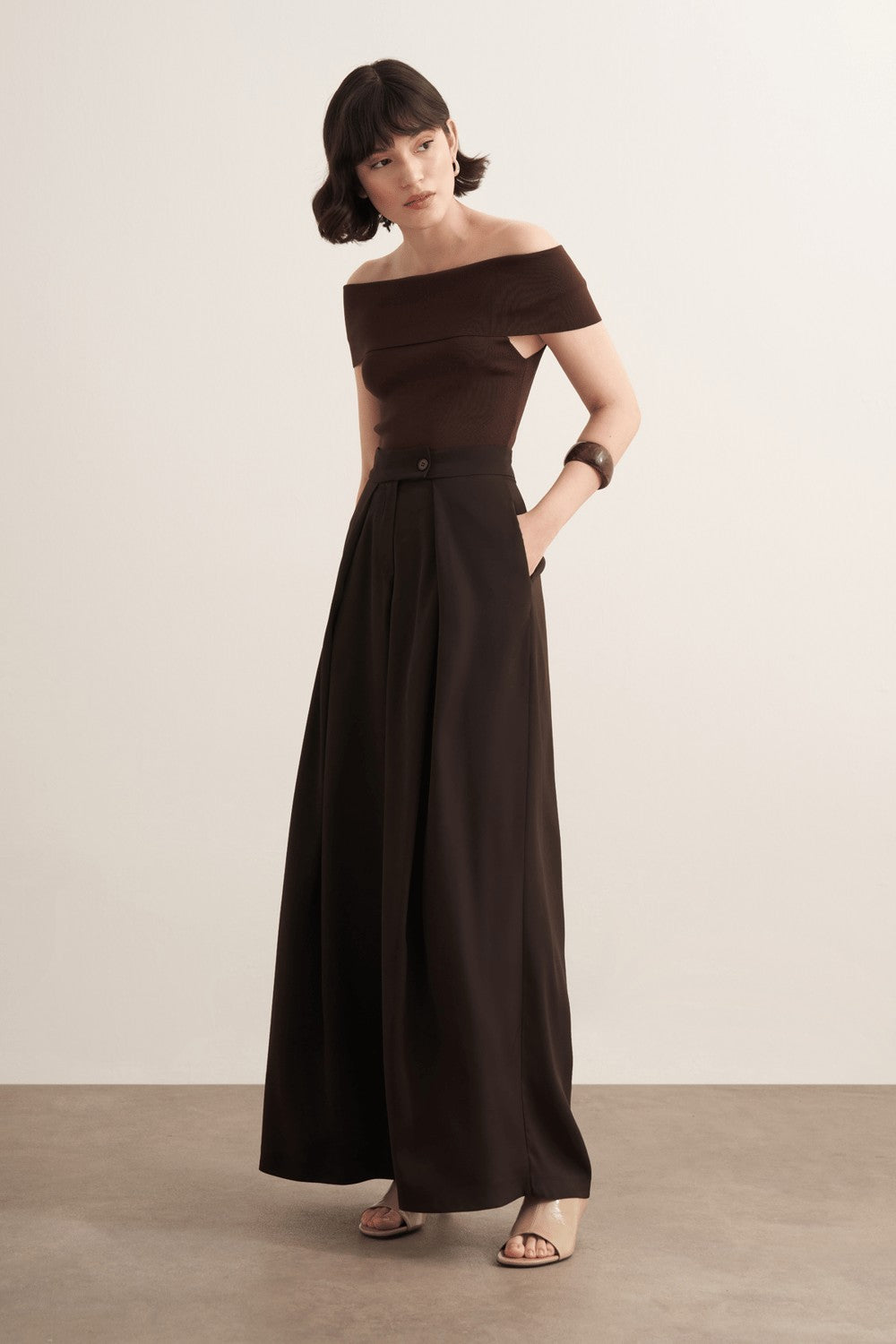 Cherianne.com Leona high-waisted wide-leg trousers in dark brown polyester with a ruffled design and side pockets.