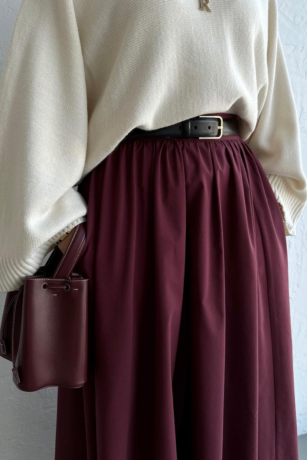 Cherianne.com burgundy poplin flared skirt with pockets, styled with a cream knit sweater and black belt.