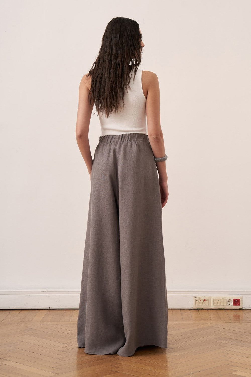 Cherianne.com wide-leg grey linen trousers with an elasticated waist worn by a model in a studio setting.