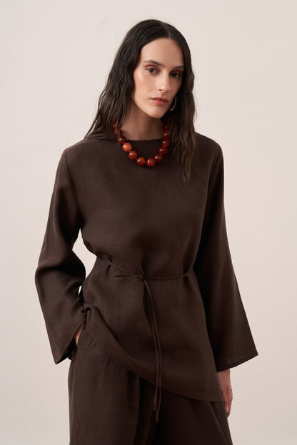 Cherianne.com dark brown linen blouse with wide sleeves, crew neck, and adjustable waist tie on a model.