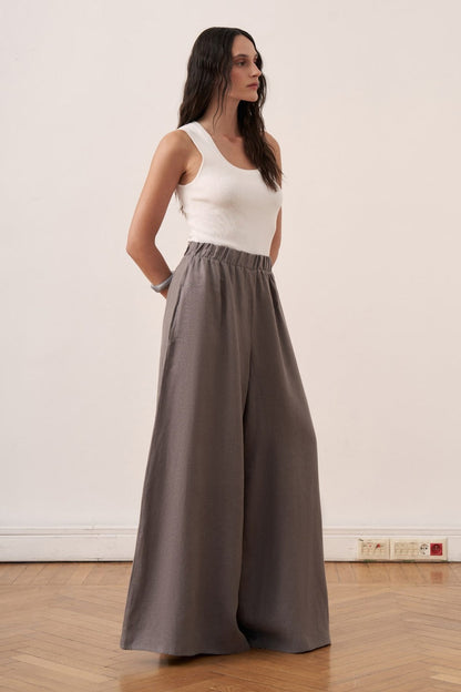 Cherianne.com wide-leg grey linen trousers with an elasticated waist worn by a model in a studio setting.
