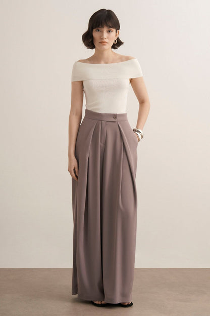 Cherianne.com Leona high-waisted wide-leg trousers in taupe with pleated details and side pockets on a model.