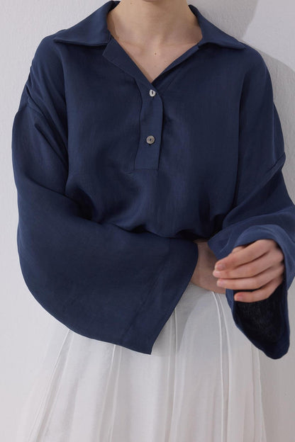 Cherianne.com navy blue linen blend blouse with a shirt collar, drop shoulders, and mother-of-pearl button detail.