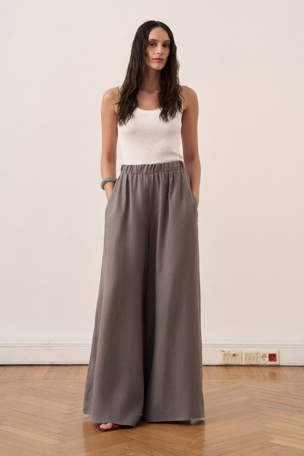 Cherianne.com wide-leg grey linen trousers with an elasticated waist worn by a model in a studio setting.
