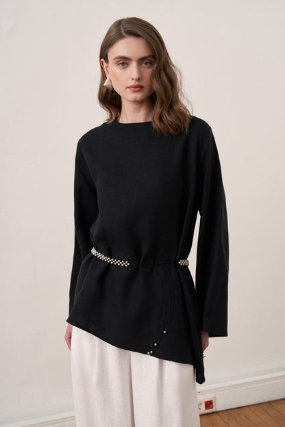 Cherianne.com black linen blouse with wide sleeves and waist tie, paired with white wide-leg trousers on a model.