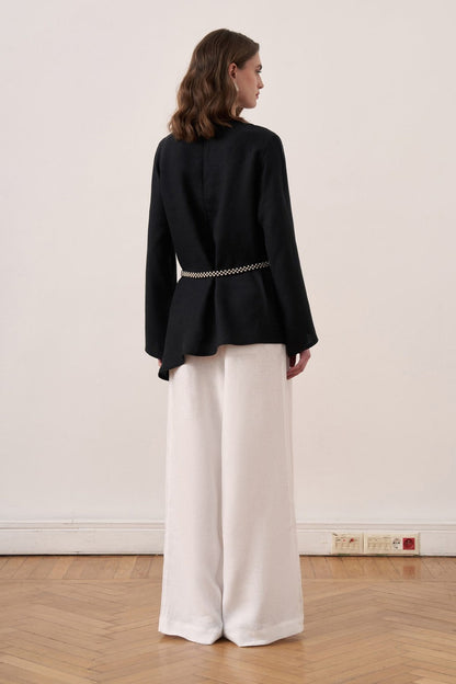 Cherianne.com black linen blouse with wide sleeves and waist tie, paired with white wide-leg trousers on a model.