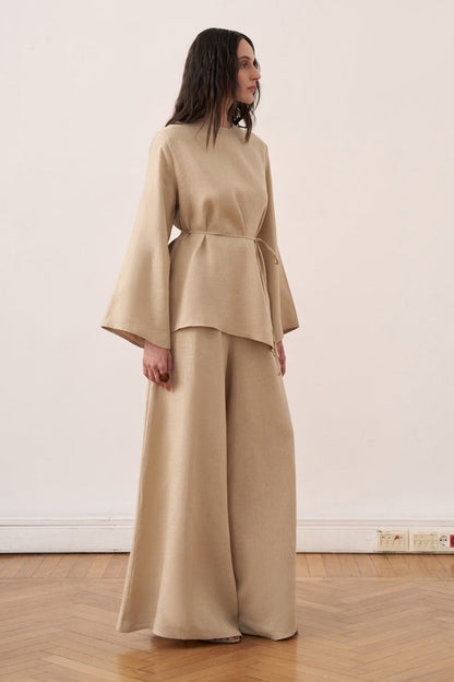 Cherianne.com wheat beige linen blouse with wide bell sleeves and a tie-waist, paired with matching wide-leg trousers.