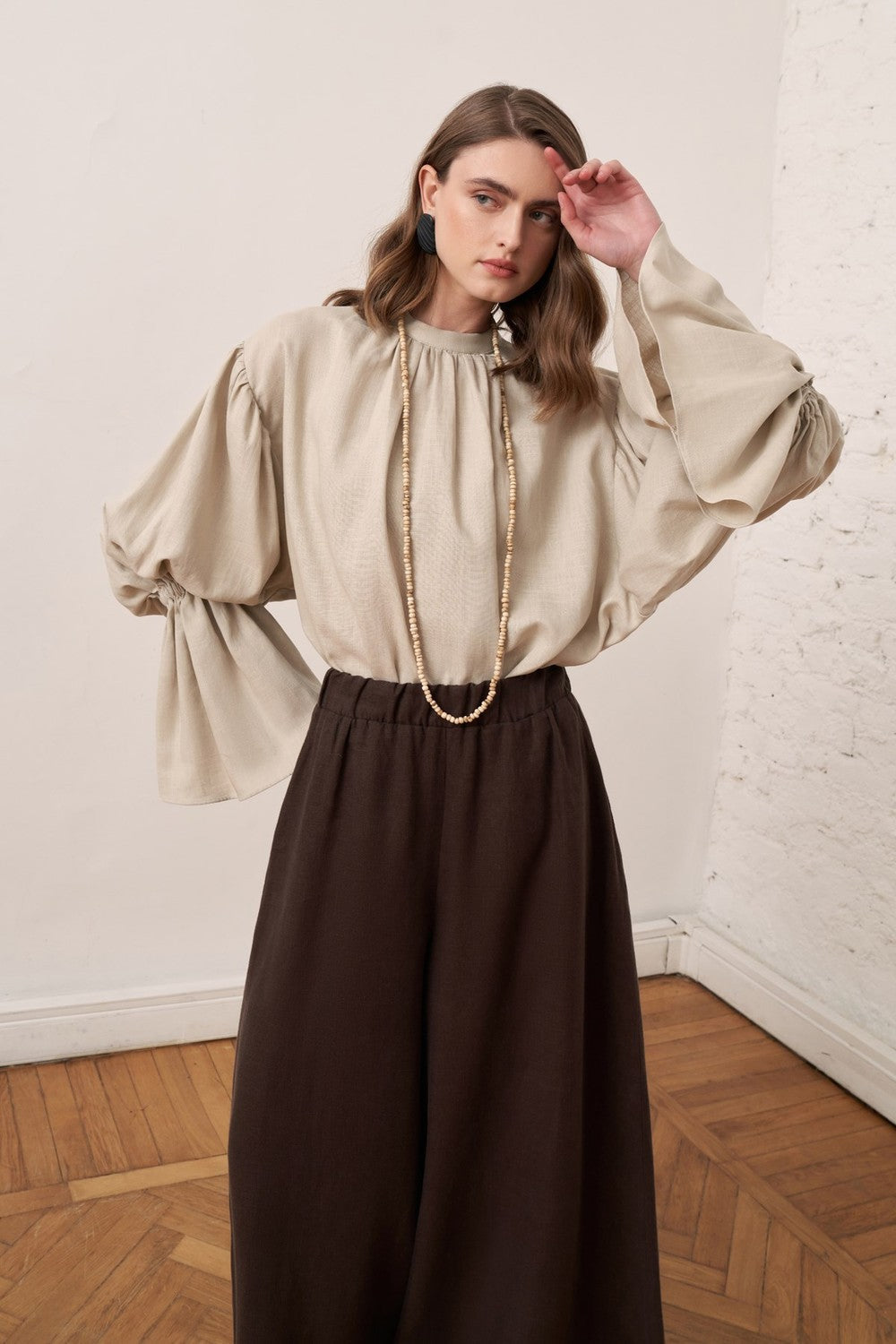 Cherianne.com beige linen blend blouse with voluminous balloon sleeves and gathered cuffs worn by a model