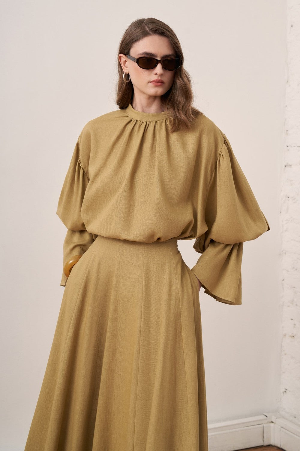 Cherianne.com beige linen blend blouse with voluminous balloon sleeves and gathered cuffs worn with a matching skirt.