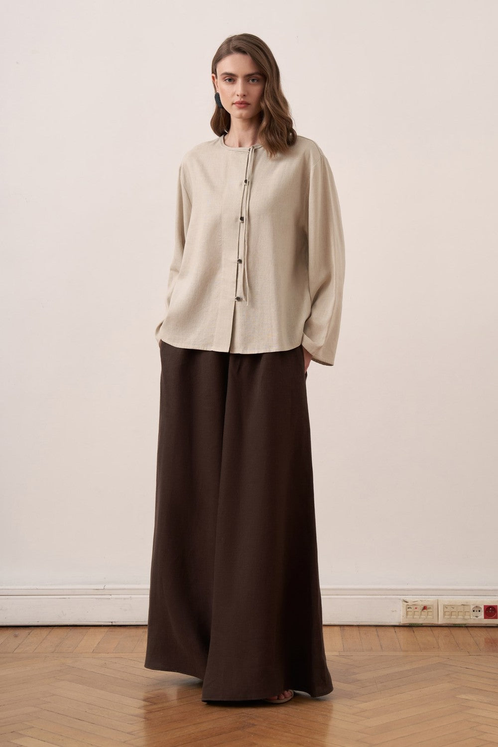 Cherianne.com beige linen shirt with mandarin collar, asymmetric button placket, and long sleeves on a model.