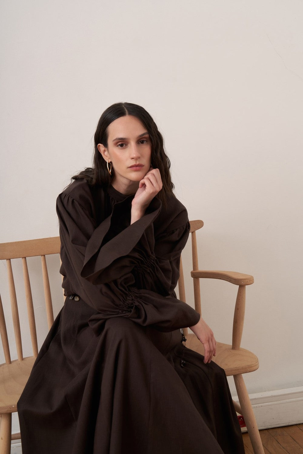 Cherianne.com dark brown linen blend blouse with voluminous balloon sleeves and gathered high neck detail on a model.