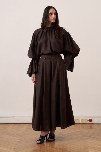 Cherianne.com dark brown linen blend blouse with voluminous balloon sleeves and gathered high neck detail on a model.