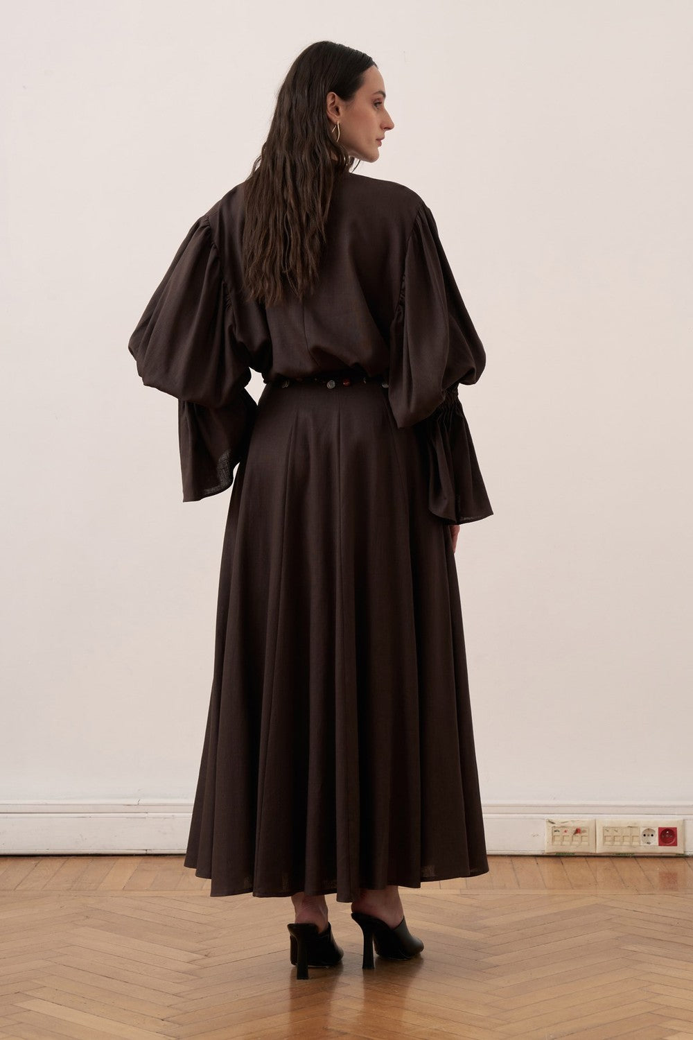 Cherianne.com dark brown linen blend blouse with voluminous balloon sleeves and gathered high neck detail on a model.