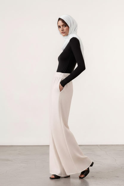 Cherianne.com wide-leg linen trousers in cream with an elastic waistband and side pockets worn by a model