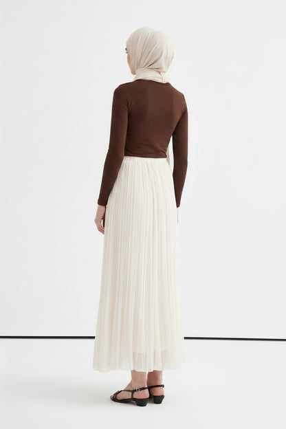 Cherianne.com ecru crush chiffon pleated maxi skirt worn with a brown long-sleeve top and headscarf, back view