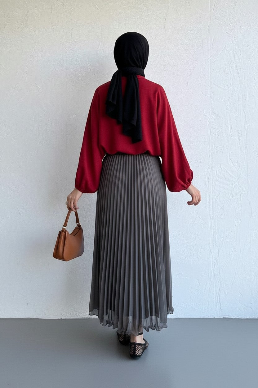 Cherianne.com gray pleated chiffon maxi skirt worn by a woman with a black hijab and red long-sleeve top