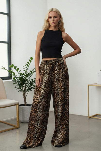 Cherianne.com brown leopard print satin wide leg trousers with an elasticated waist worn by a blonde model.