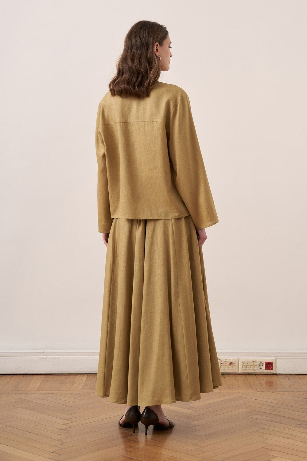 Cherianne.com mustard yellow linen shirt and matching long skirt worn by a model, back view