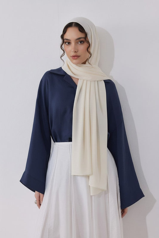 Cherianne.com navy blue loose-fit blouse with mother-of-pearl buttons, worn with a cream hijab and white skirt.