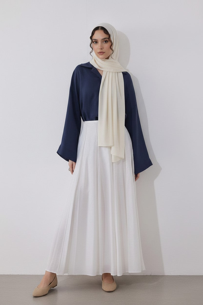 Cherianne.com navy blue loose-fit linen blend blouse with mother-of-pearl buttons, worn with a white skirt and hijab.