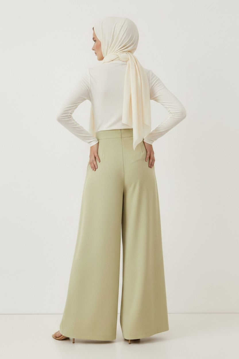 Cherianne.com sage green high-waisted wide-leg trousers with ruffled details worn by a model in a hijab