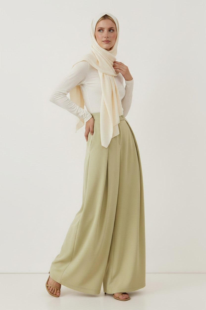 Cherianne.com sage green high-waisted wide-leg trousers with pleated detail worn by a model in a white top and hijab