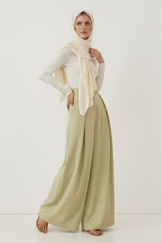 Cherianne.com sage green high-waisted wide-leg trousers with pleated detail worn by a model in a white top and hijab