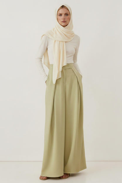 Cherianne.com high-waisted sage green wide-leg trousers with pockets worn by a model in a cream hijab and top.
