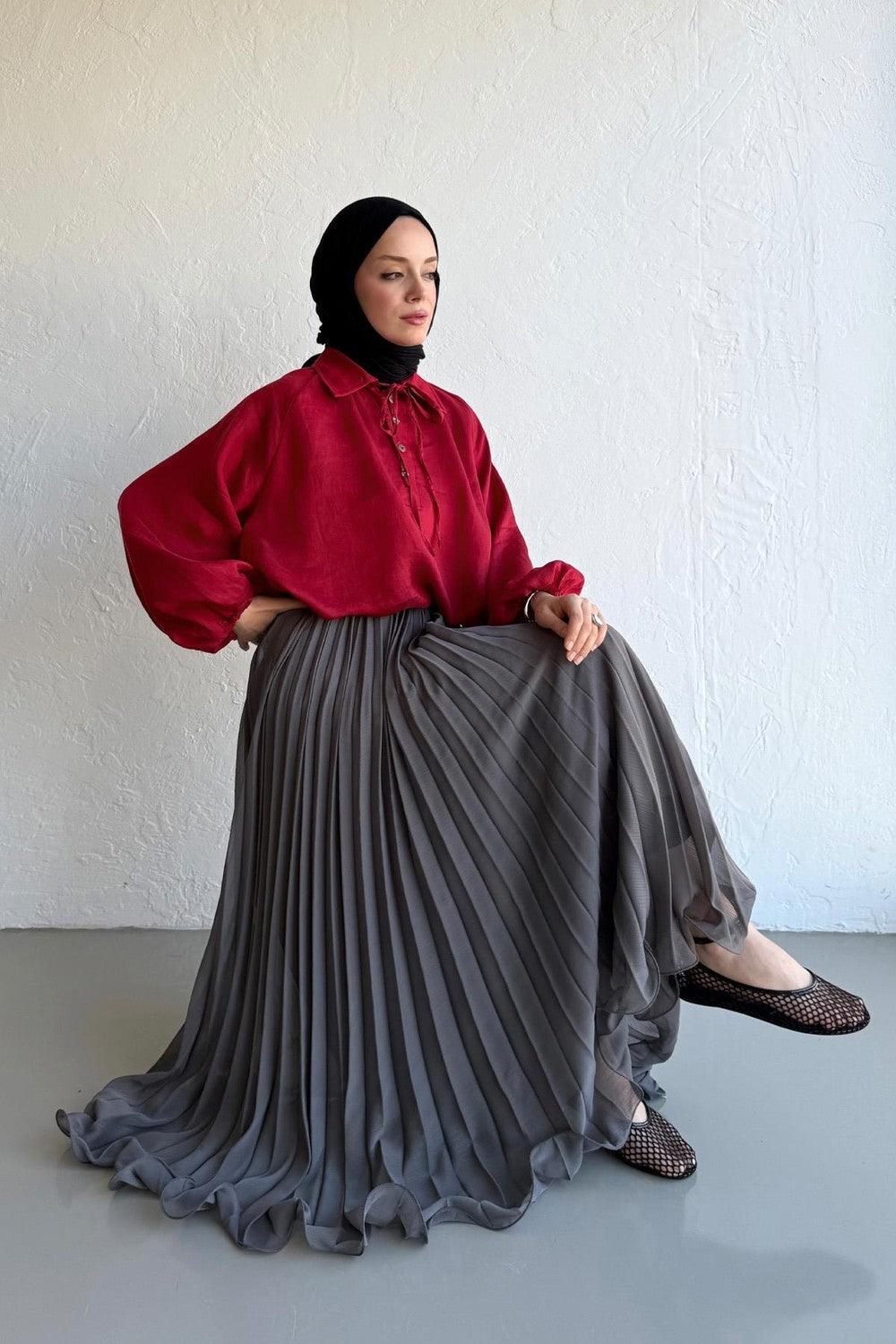 Cherianne.com gray pleated chiffon maxi skirt worn by a model with a red blouse and black hijab