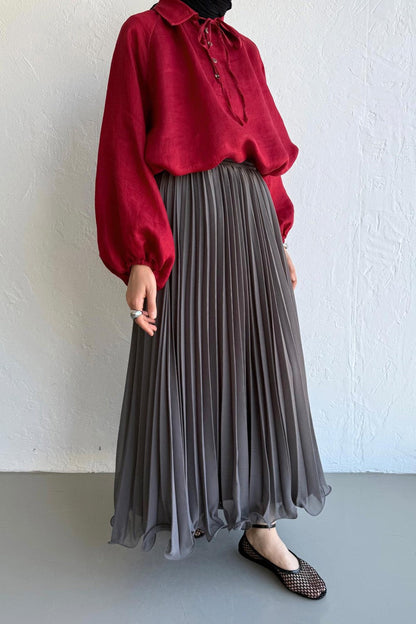 Cherianne.com gray pleated maxi skirt in chiffon fabric, styled with a long-sleeved red blouse.