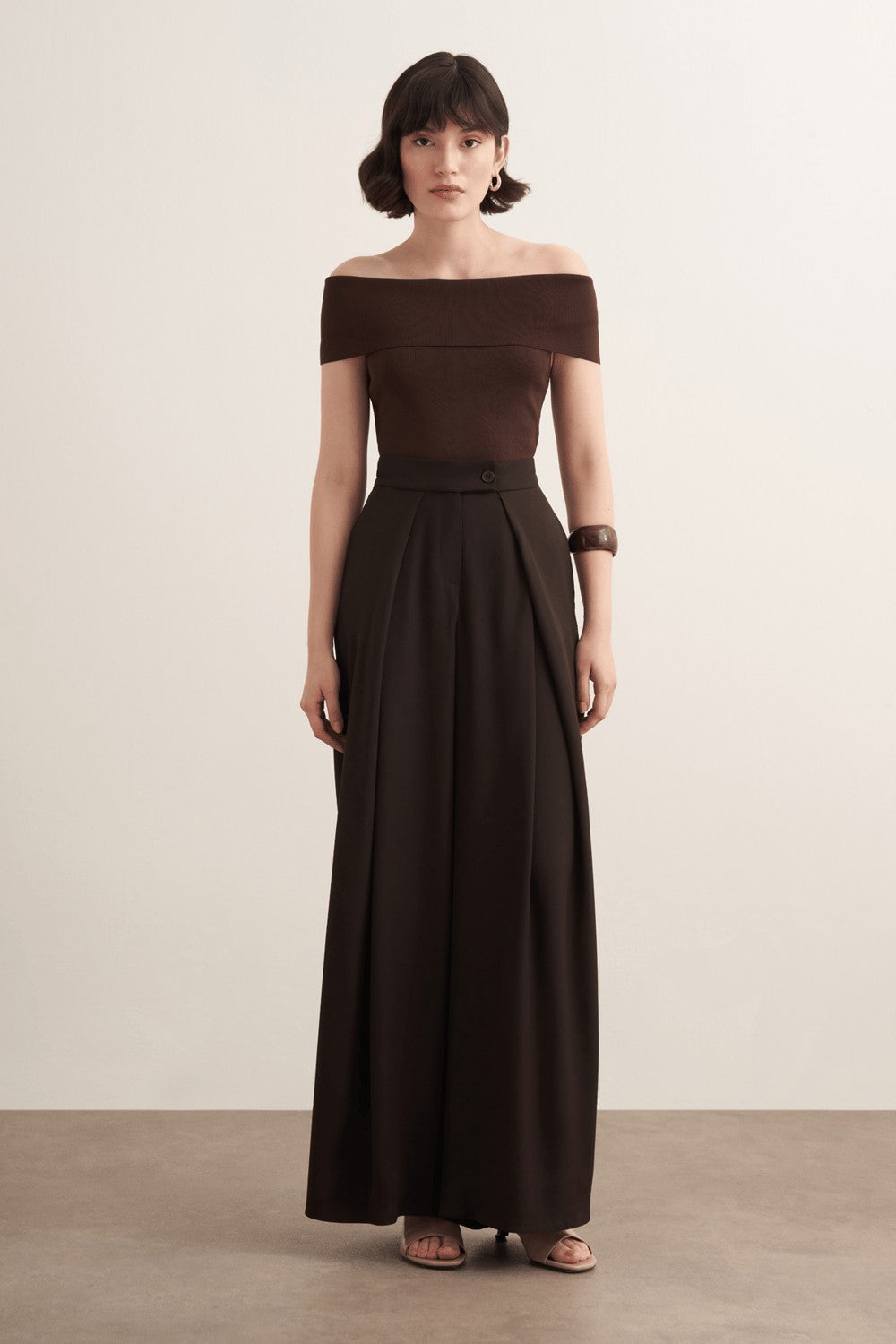 Cherianne.com Leona high-waisted wide-leg trousers in dark brown polyester with a ruffled design and side pockets.