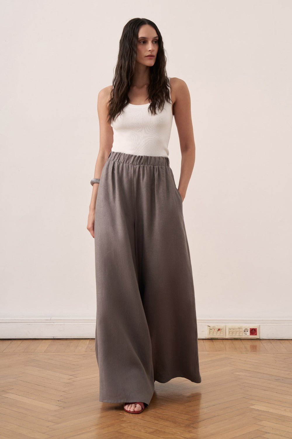 Cherianne.com wide-leg grey linen trousers with an elasticated waist worn by a model in a studio setting.